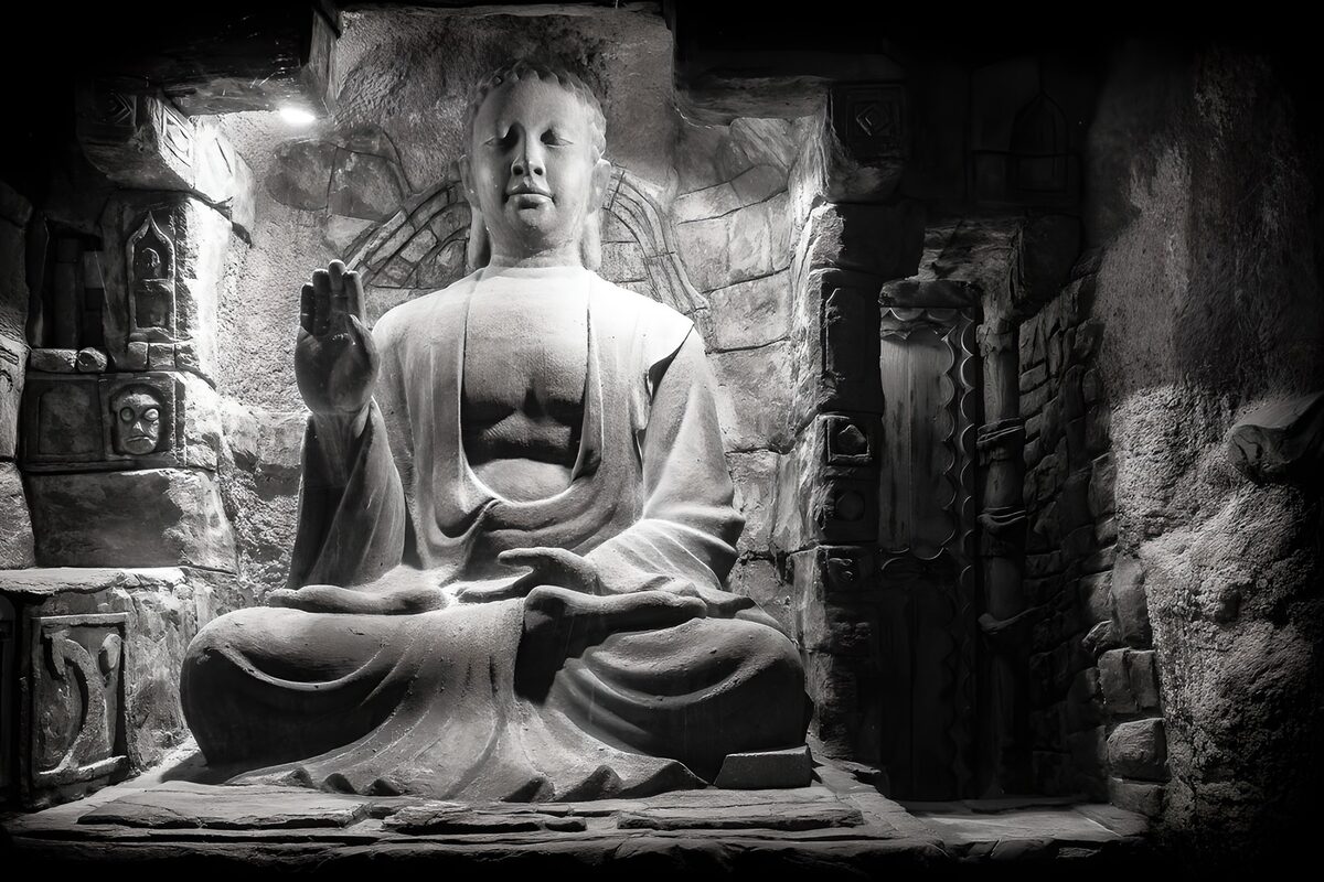 Siddende stenbuddha i en mørk niche