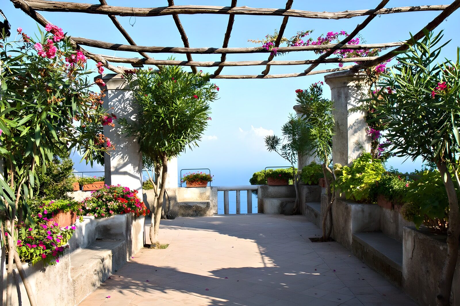 HPDK73700: Solrig terrasse med blomster og havudsigt