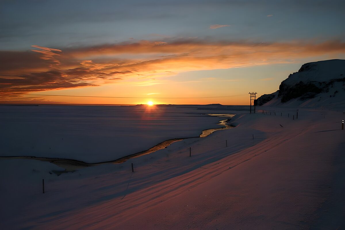 Snedækket kyst i solnedgang