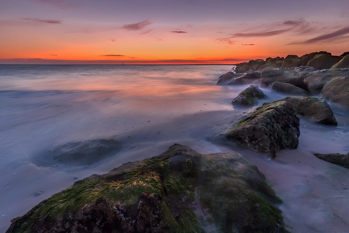 Stenet kyst i solnedgang