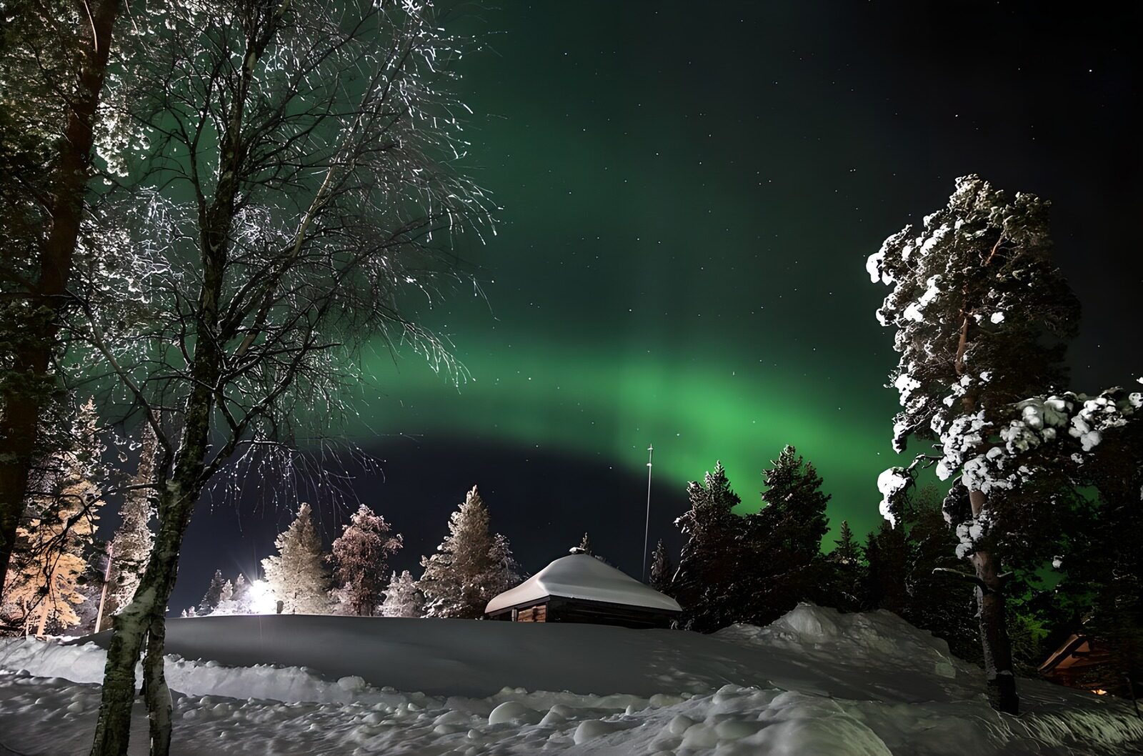 HPDK46957: Nordlys over en hytte i den stille sneskov