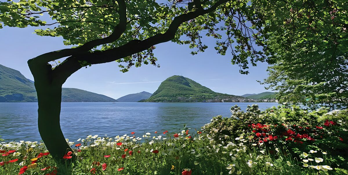 Blå sø med bjerge og blomster