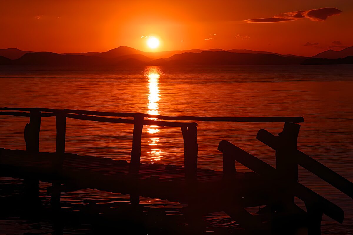 Træbro i rolig solnedgang ved bjergene