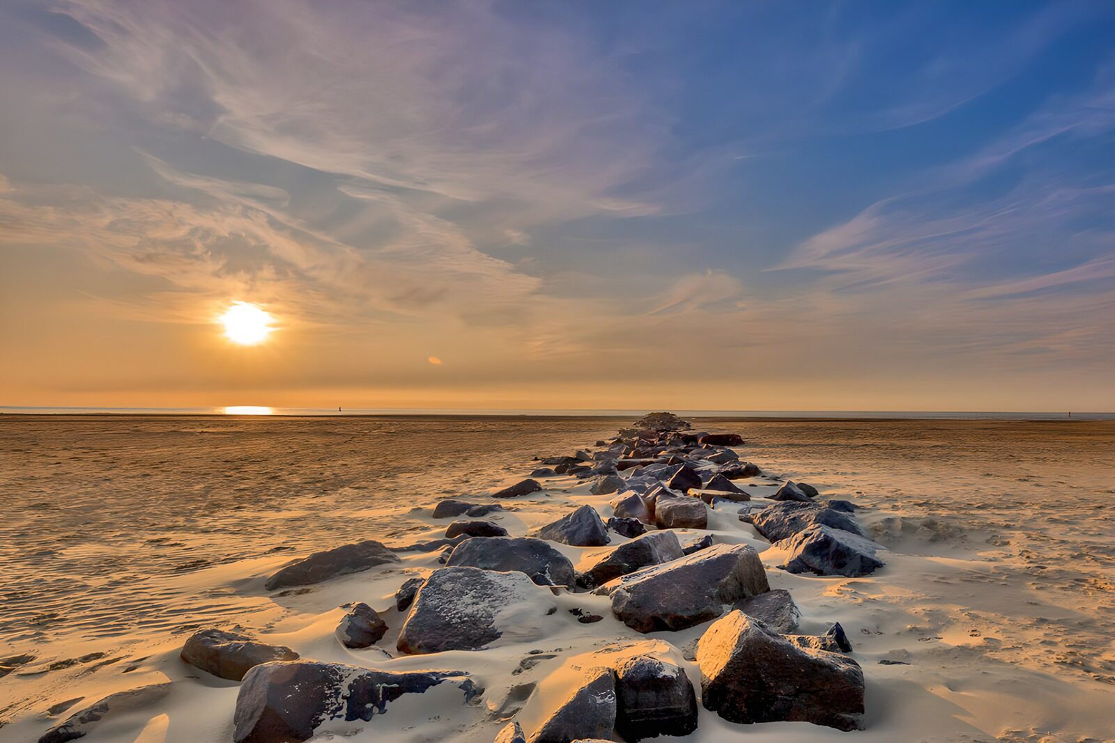 HPDK93577: Stenmole på sandstranden i solnedgang