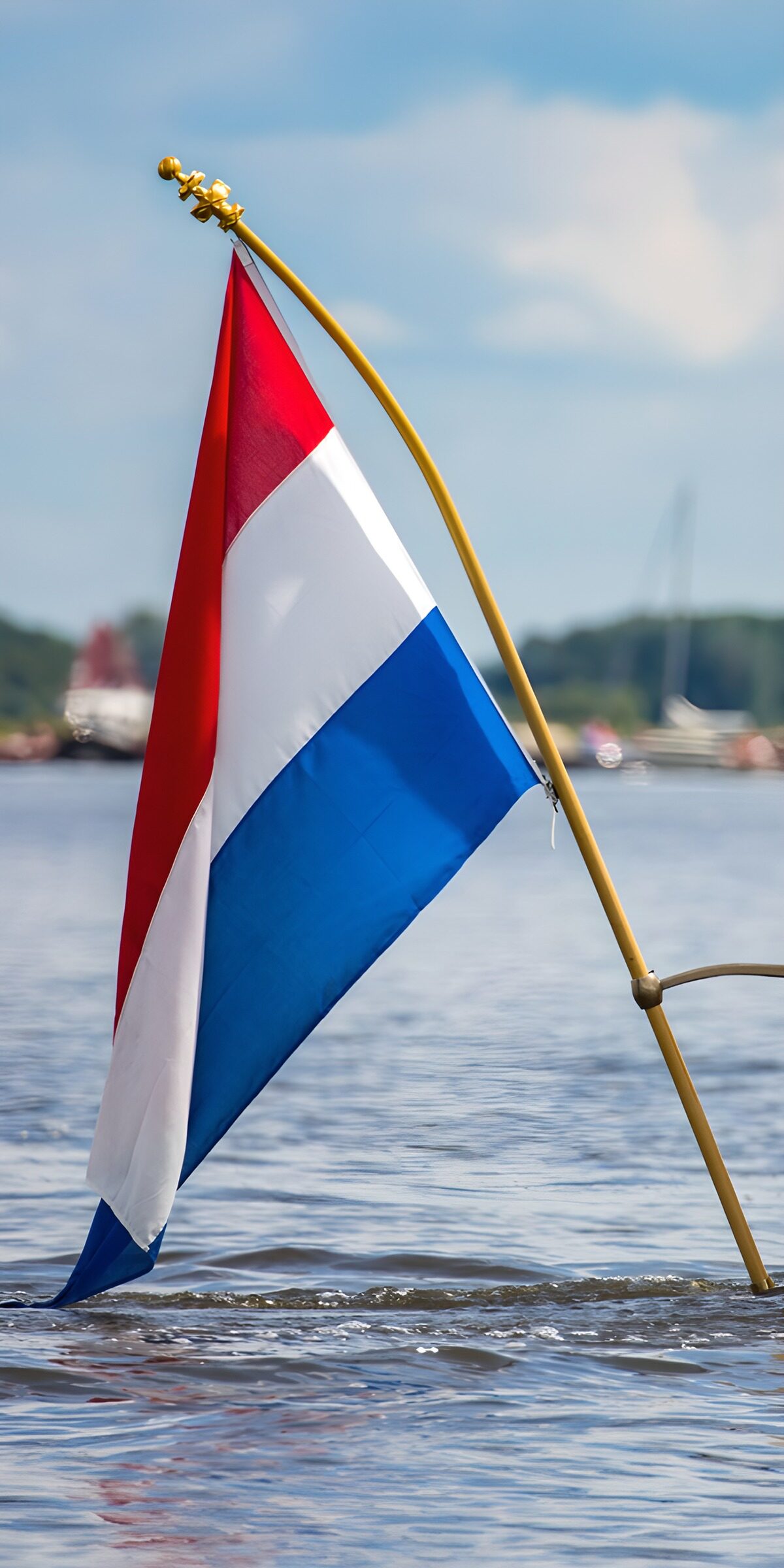 HPDK90114: Hollandsk flag over solglitrende vand