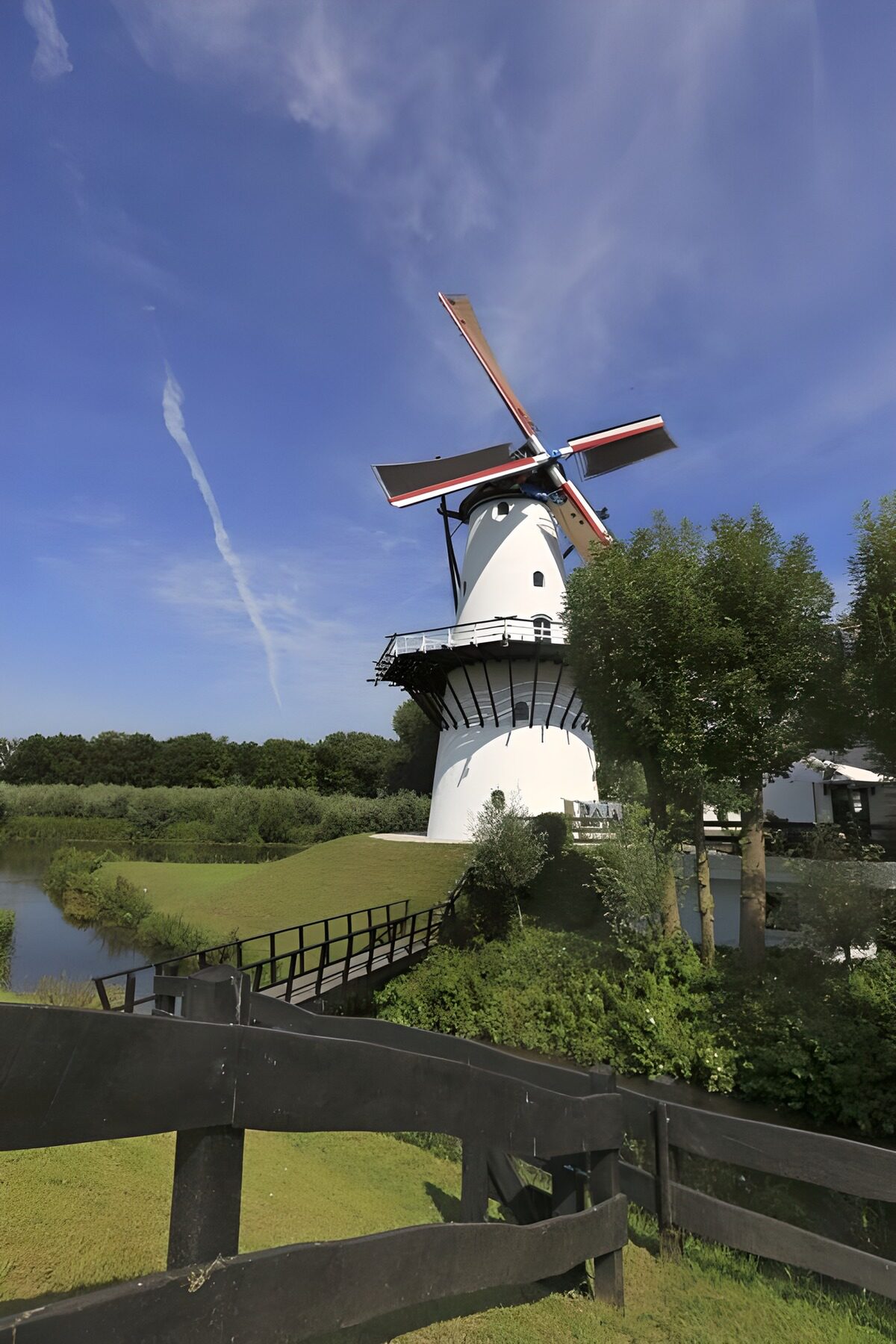 HPDK74265: Hvid vindmølle ved en stille kanal