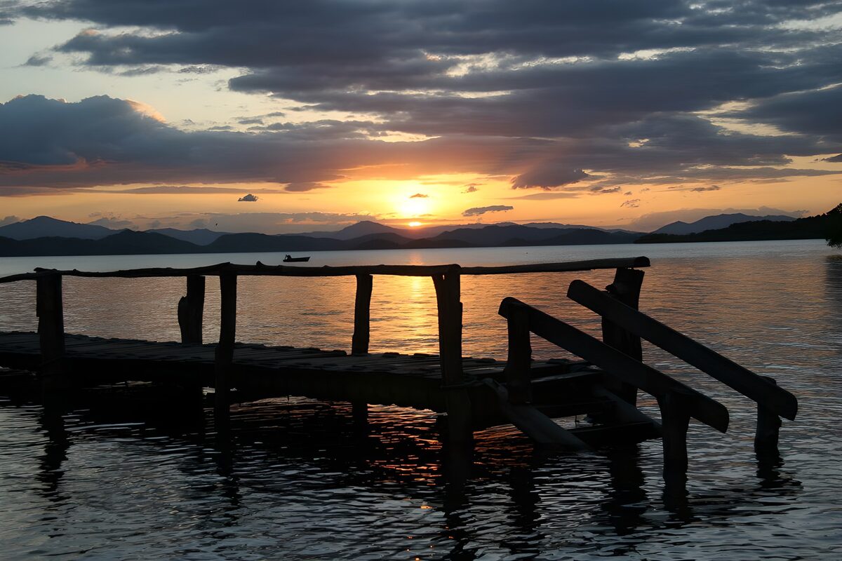 Træbro ved søen i solnedgang