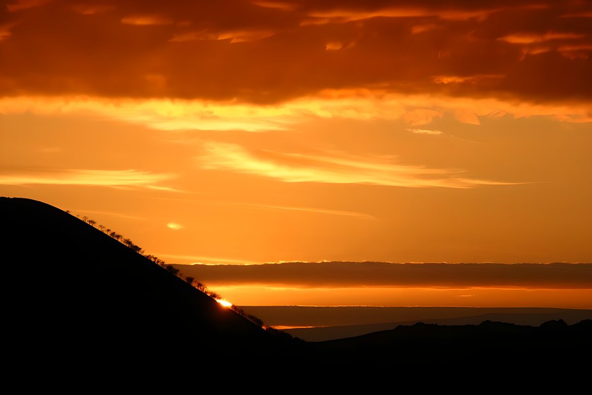 Solnedgang bag den mørke bakkeskråning