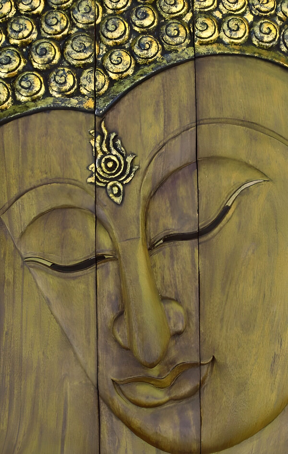 Buddhaansigt i træ med et fredfyldt smil