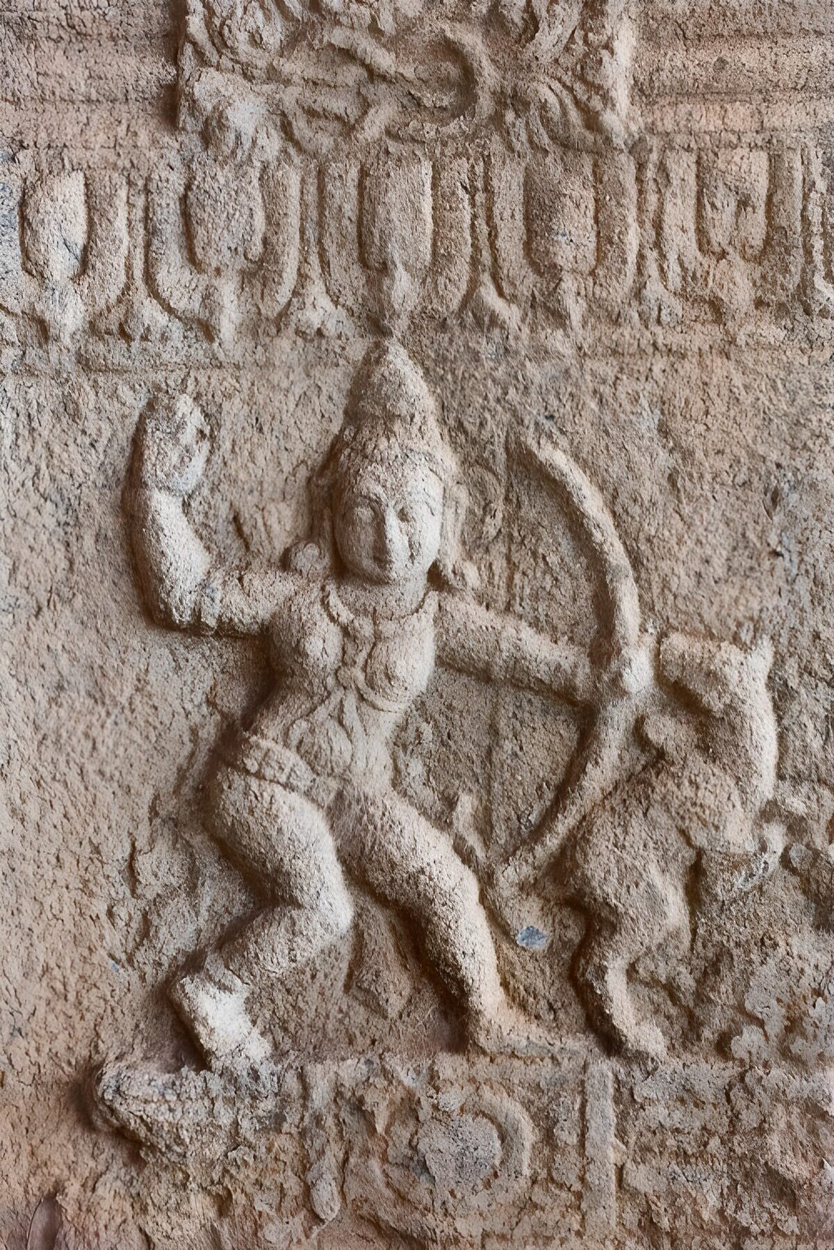 Slidt stenrelief med figur og bue