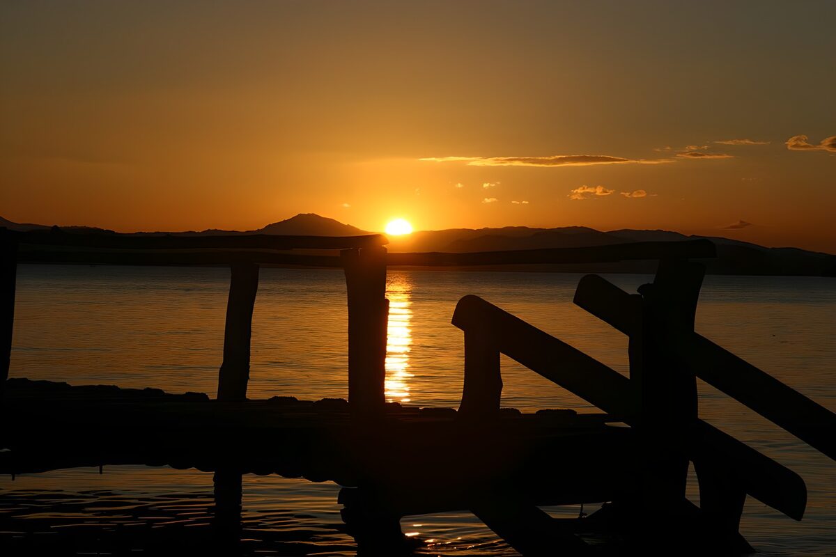 Træbro i silhuet ved solnedgang