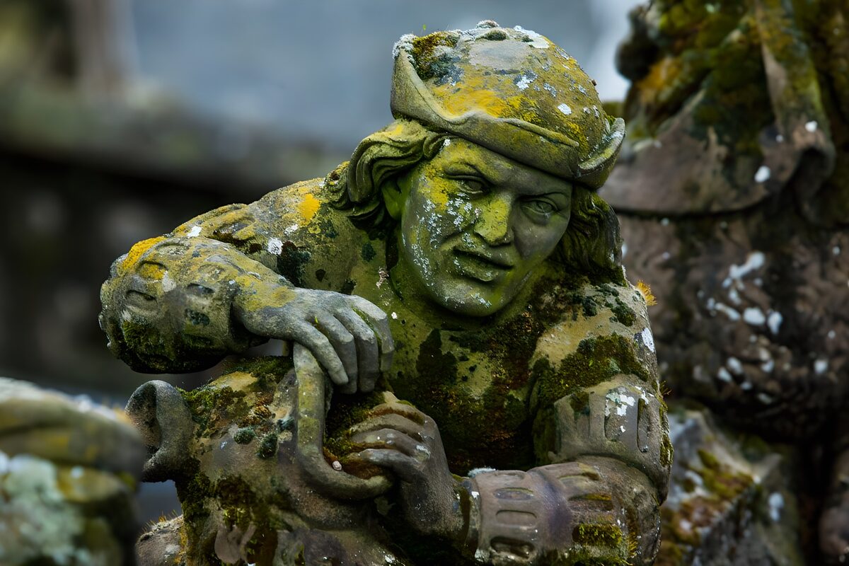Mosbegroet stenfigur med hat og kande