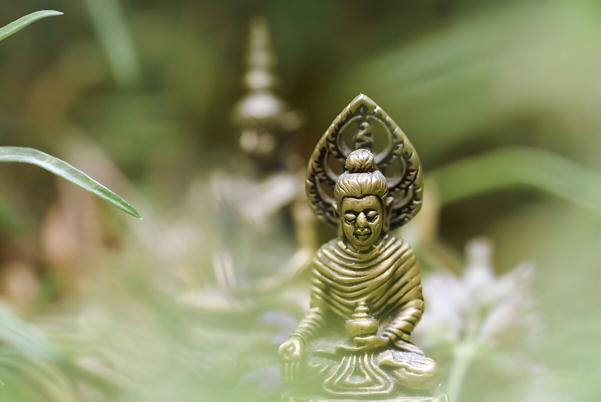Gylden Buddha mellem grønne blade